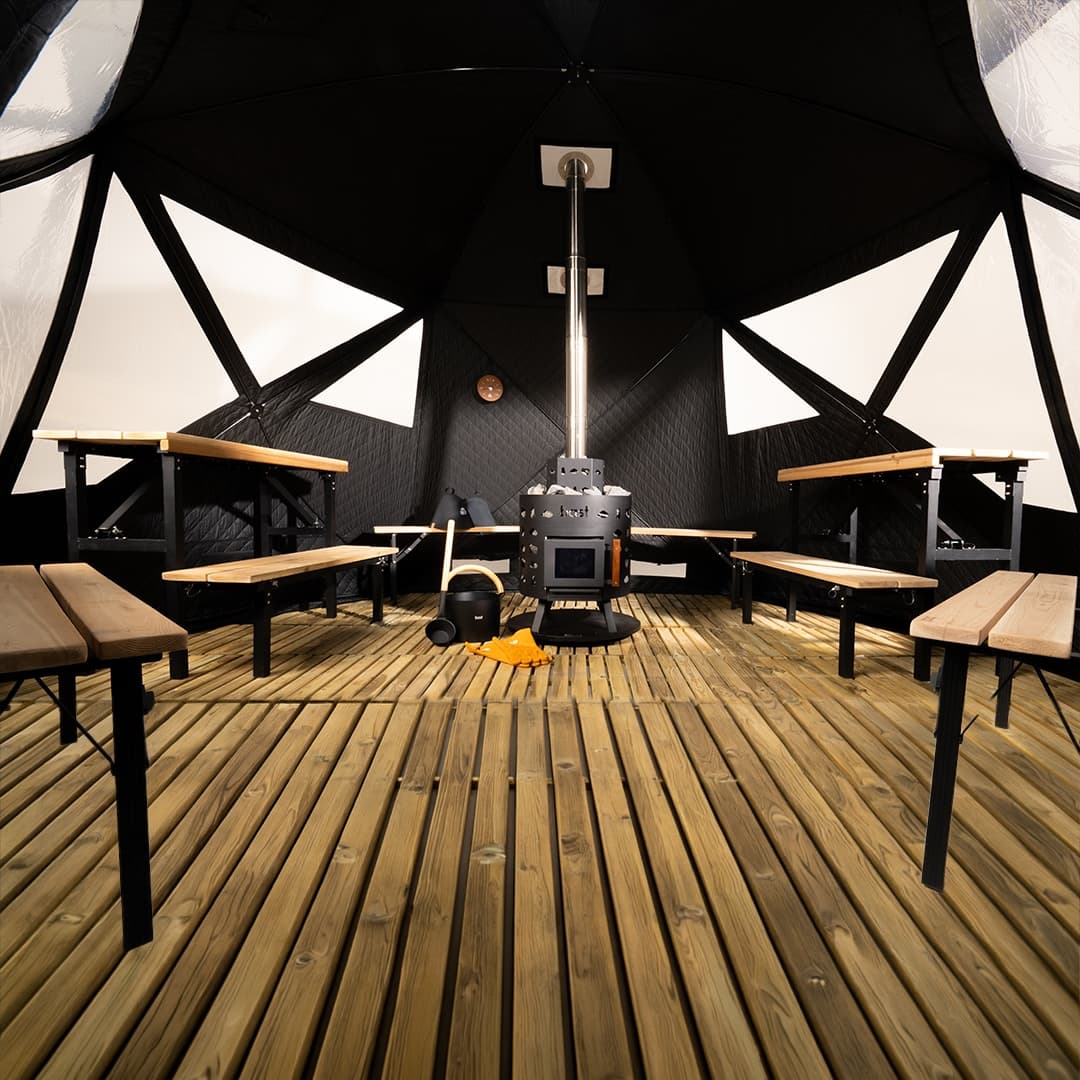 Inside the upcoming Bast Stam Premium sauna tent with benches around a central wood stove