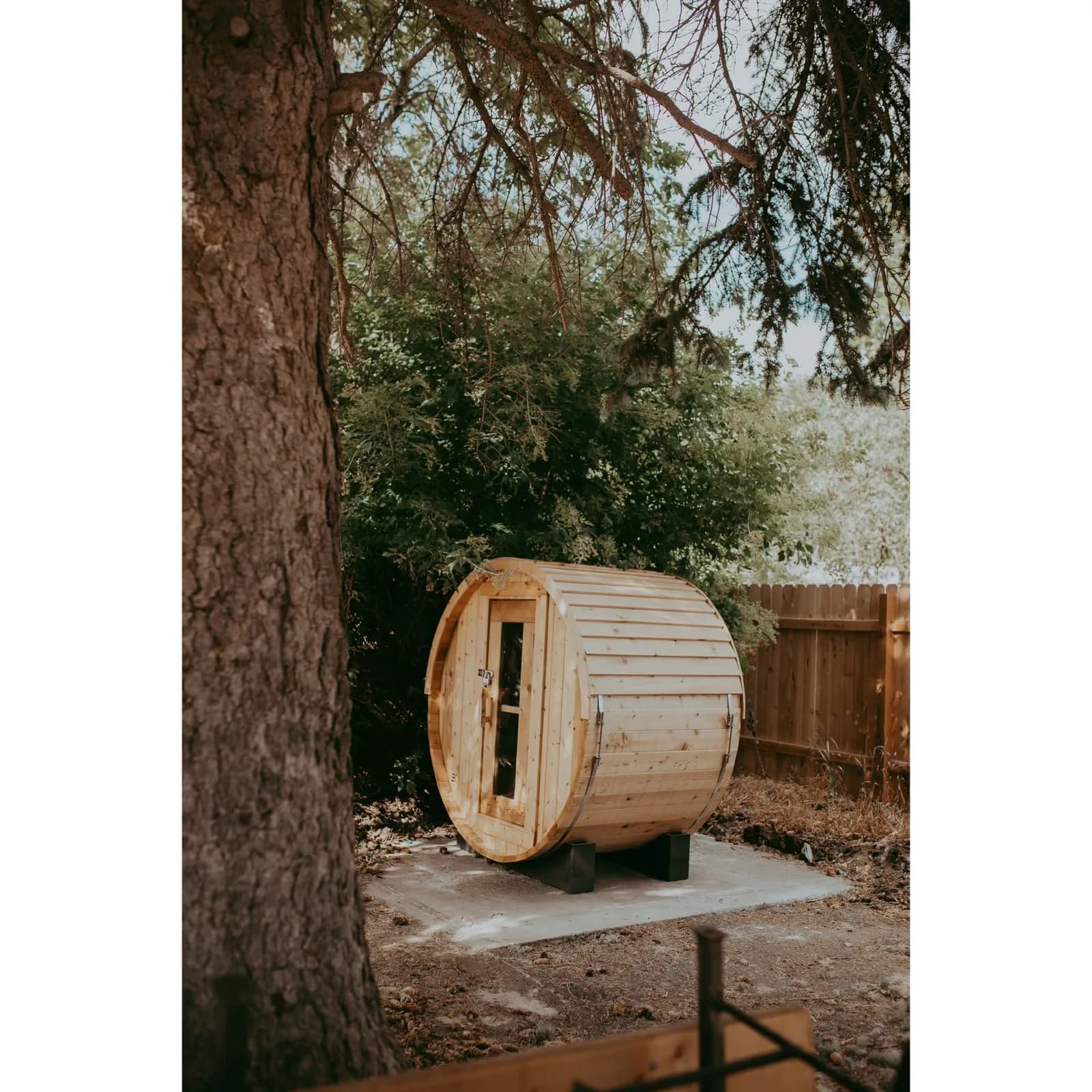 Sweat Kingdom barrel sauna installed beneath trees